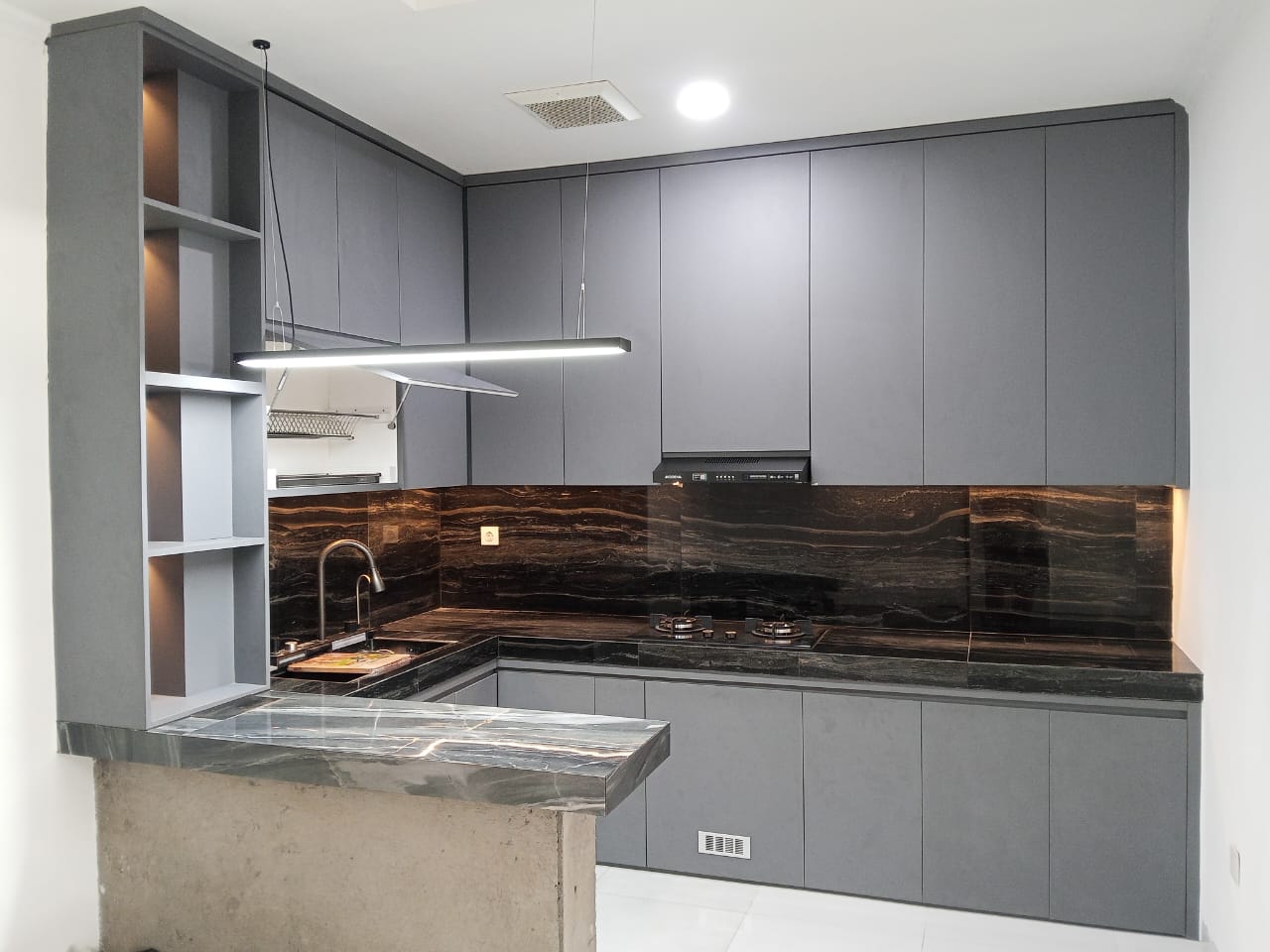 Kitchen set modern abu-abu dengan kabinet custom dan countertop motif marmer
