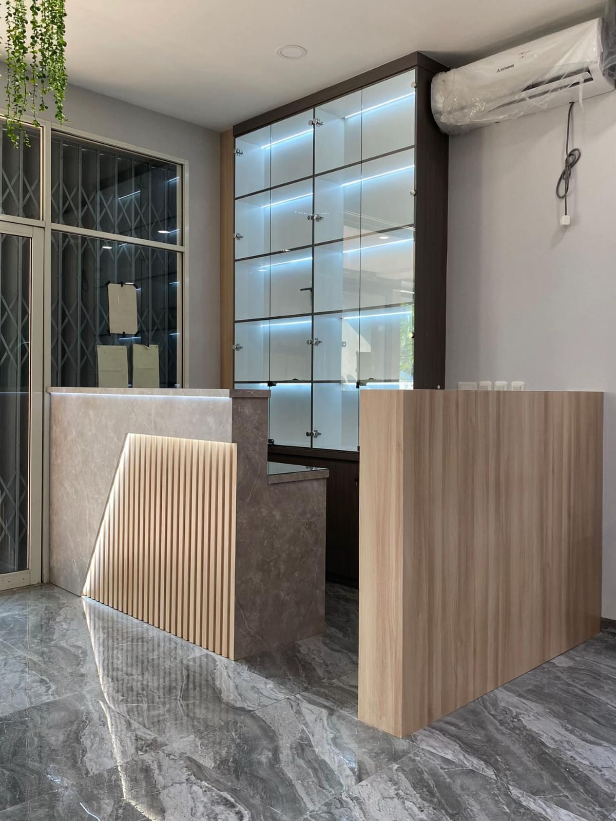 Area reception salon dengan custom display cabinet dan pencahayaan